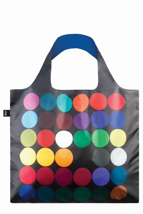 A Tote Bag with Poul Gernes Artwork with a black base is adorned with a colorful polka dot pattern. The dots are arranged in a grid and feature various solid colors including red, yellow, blue, green, and white. The bag has a simple, wide handle.