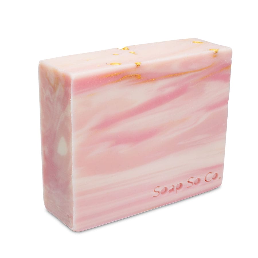 A rectangular bar of Soap So Co. soap features a stunning pink and white marbled pattern, complemented by elegant gold accents, with the brand name embossed on the side.