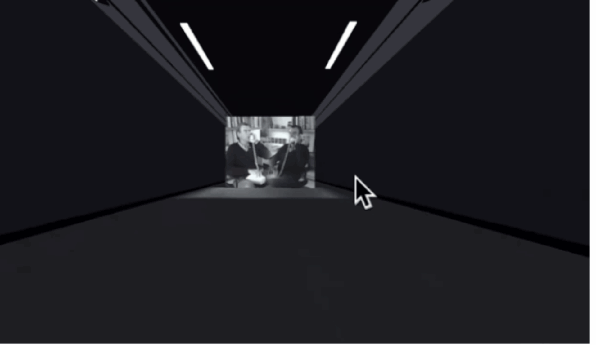 A dark corridor with a black and white image projected on the back wall. The image shows two men in suits engaged in conversation while sitting in front of bookshelves. A computer mouse cursor is visible in the foreground pointing toward the projection.