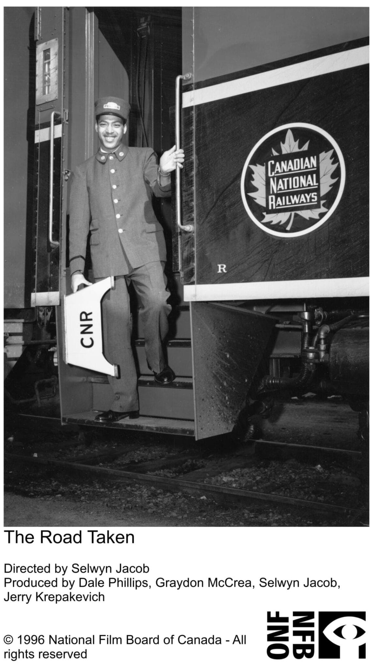 Black and white image of a Black man standing on a train car dressed in a Canadian National Railway uniform. The man is smiling.