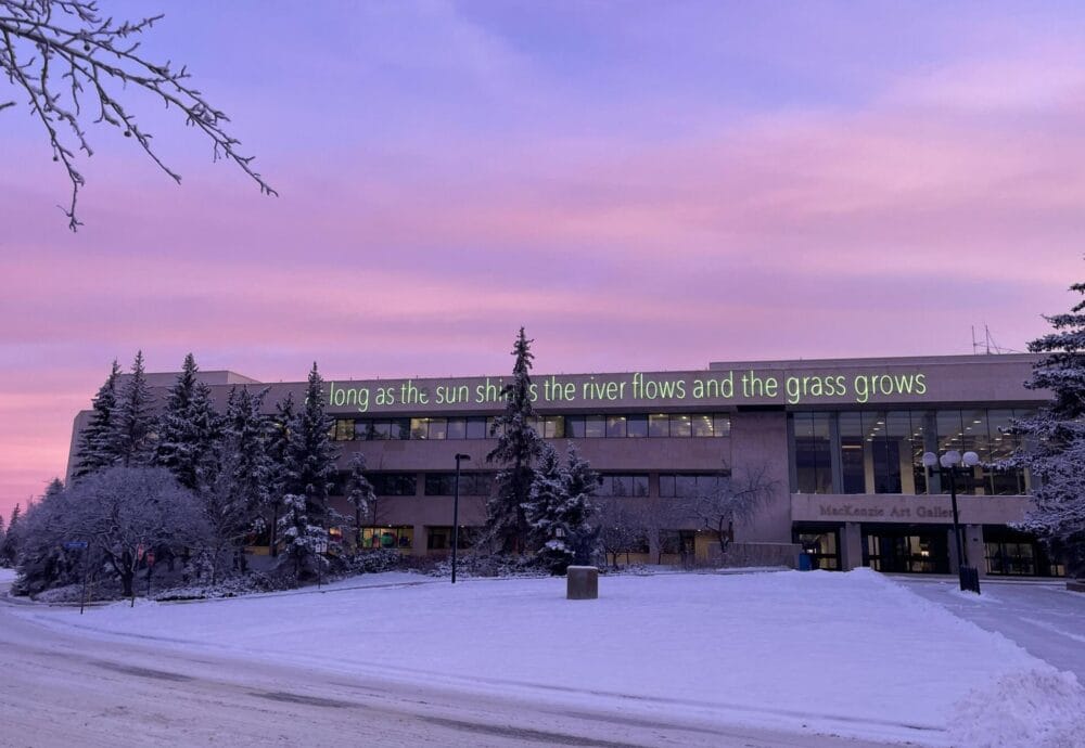 Outside view of the Gallery after a snowfall with a pink and purple sunrise.