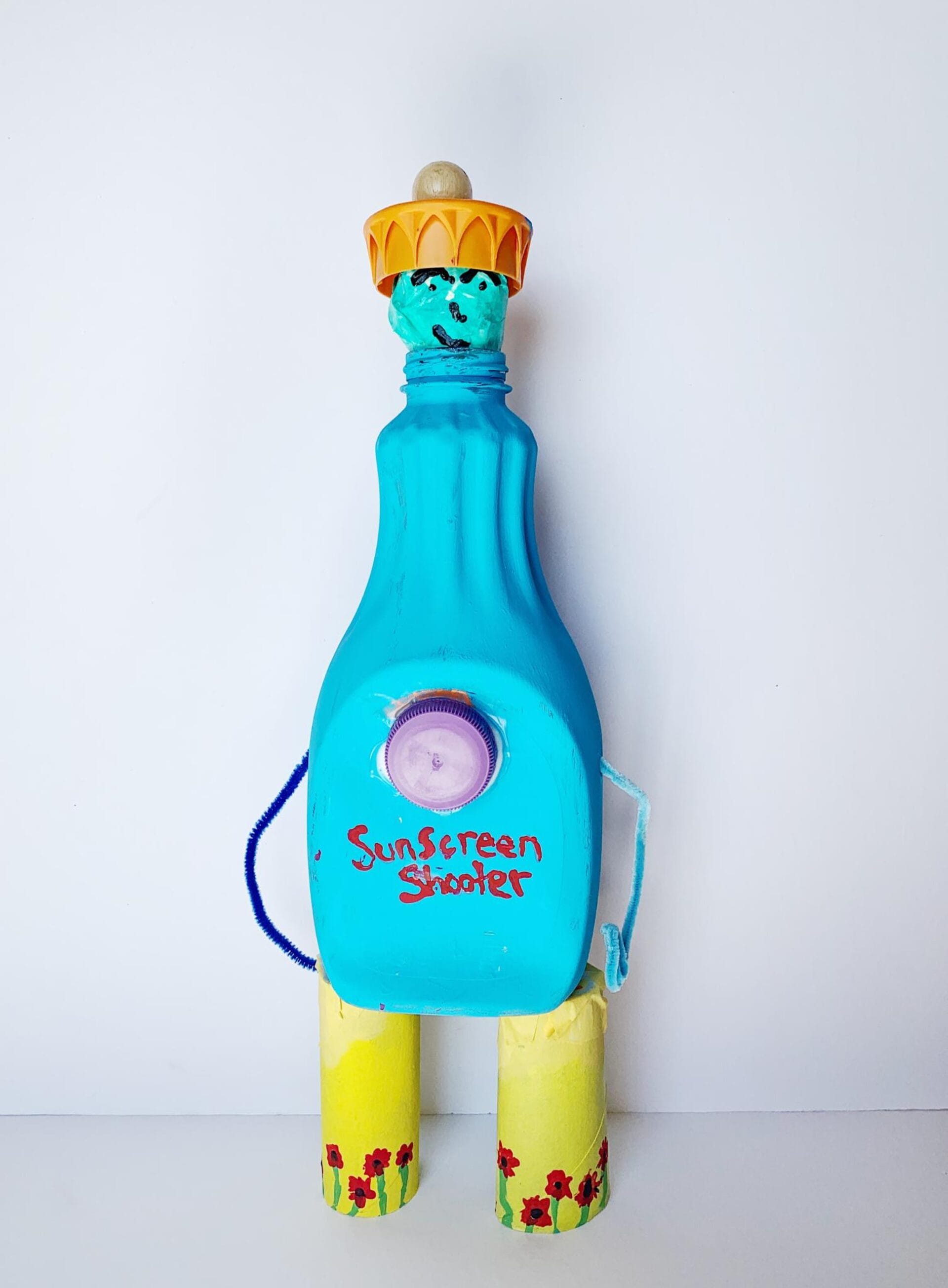 A creative, homemade robot-like figure made from a blue bottle labeled