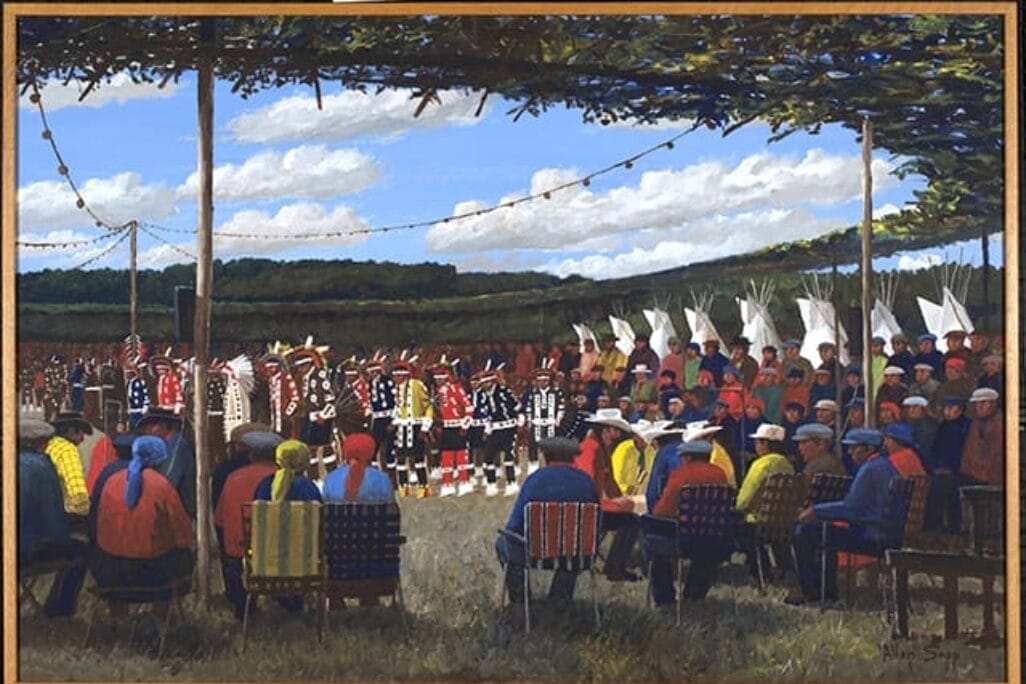 A painting depicts a cultural gathering outdoors under a large canopy. People dressed in vibrant traditional attire dance while others sit in a semicircle observing, forming the building blocks of community. The background features a lush, green landscape under a partly cloudy sky.