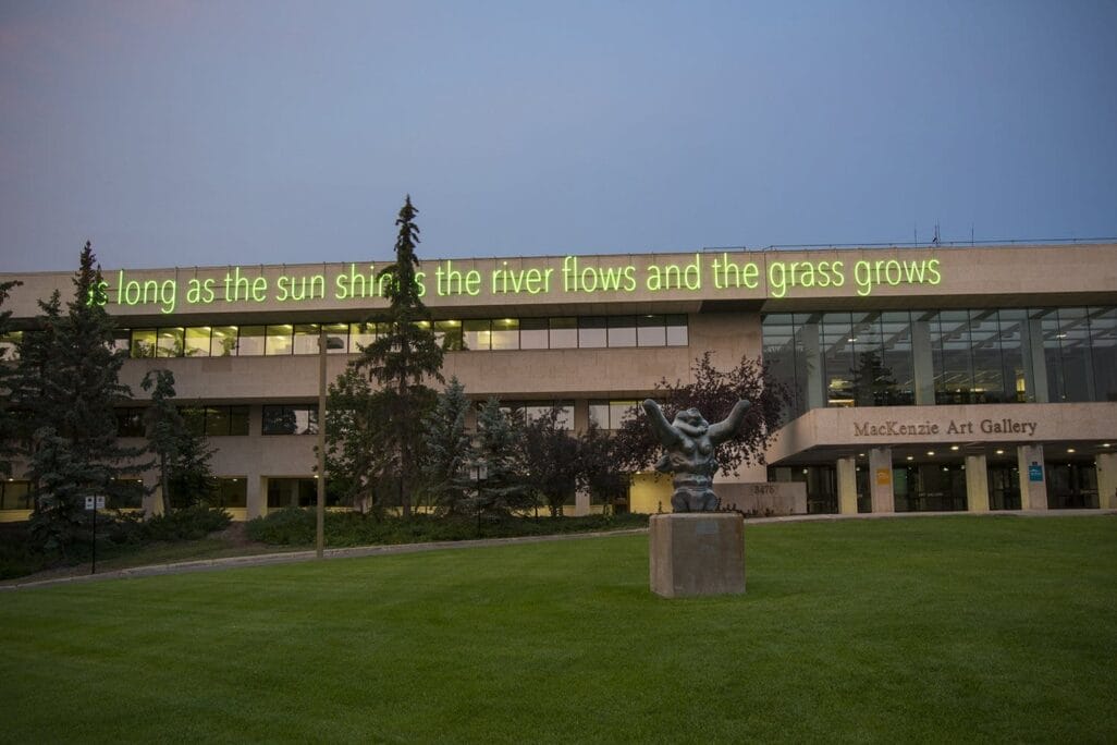 A building with a neon green sign on the roof reading, 