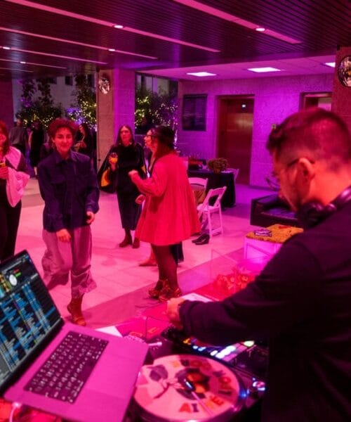 People dancing on the dance floor lit by pink lights