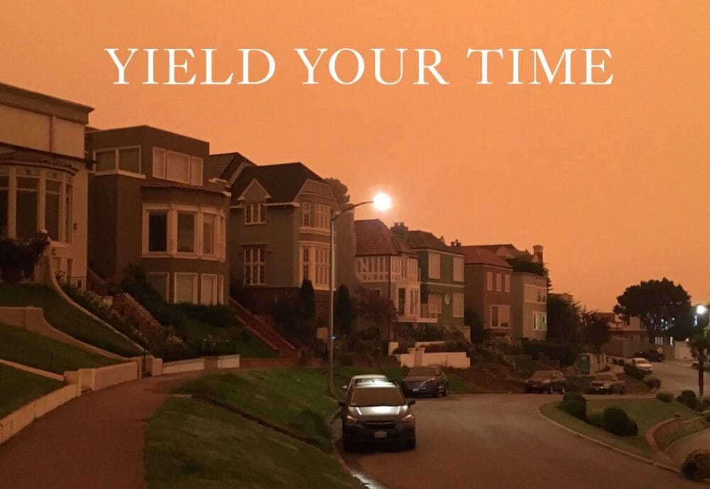 A residential street with houses under an orange-tinted sky, with 