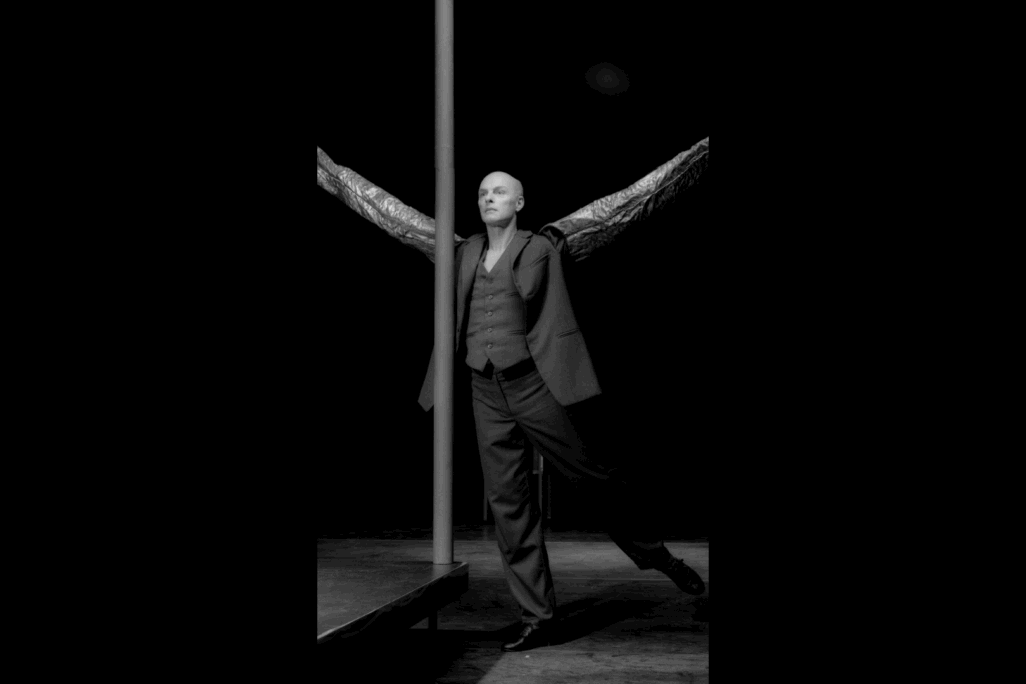 Picture in black and white of Paul-André Fortier dancing beside a tall pole with arms outstretched.