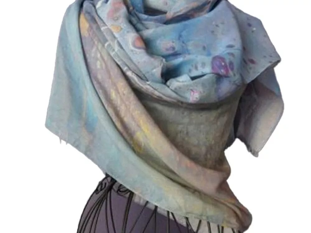 A mannequin draped with the Inception Scarf by Kay Jay Studios, featuring abstract designs in blue and gray, wrapped stylishly around the shoulders and neck.
