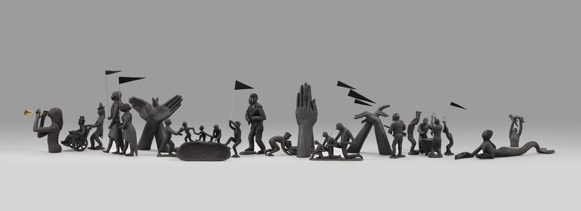 a parade of figures all coloured in black.