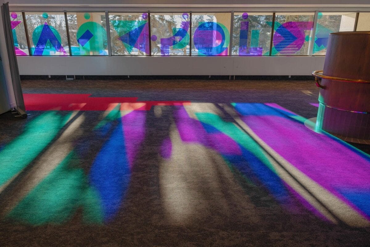 Photo of blue and purple reflections on the floor from window installation by Joi T. Arcand.