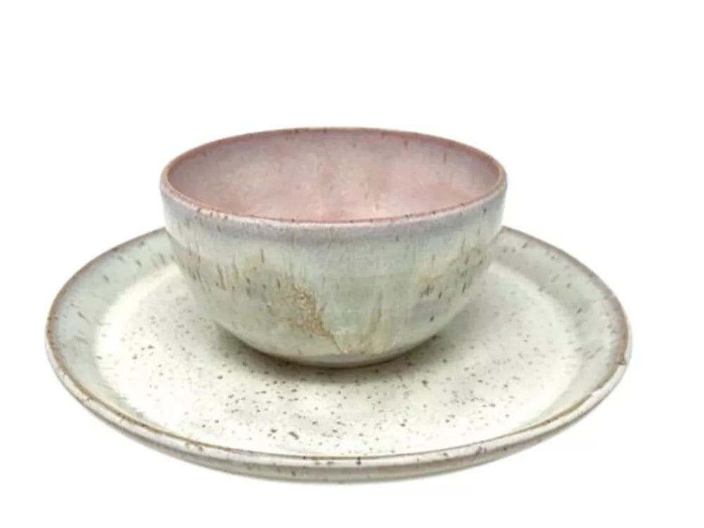 The White Speckled Dinner Plate by PrairieMoon Handmade features a rustic, handcrafted look with muted pastel speckles and a pinkish interior, paired with a matching bowl, both isolated on a white background.