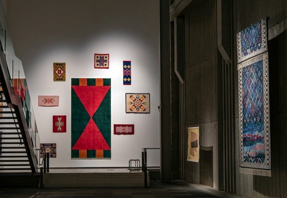 Textile works hung on the wall of a gallery.