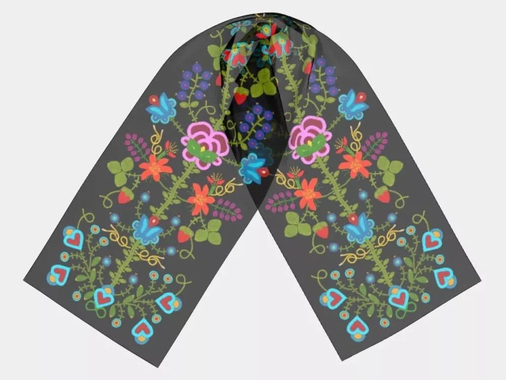 The Métis Spirit – Flower Beadwork Scarf (Copy) features a dark gray base with symmetrical red, blue, green, and pink floral and heart patterns, shown against a light gray background.
